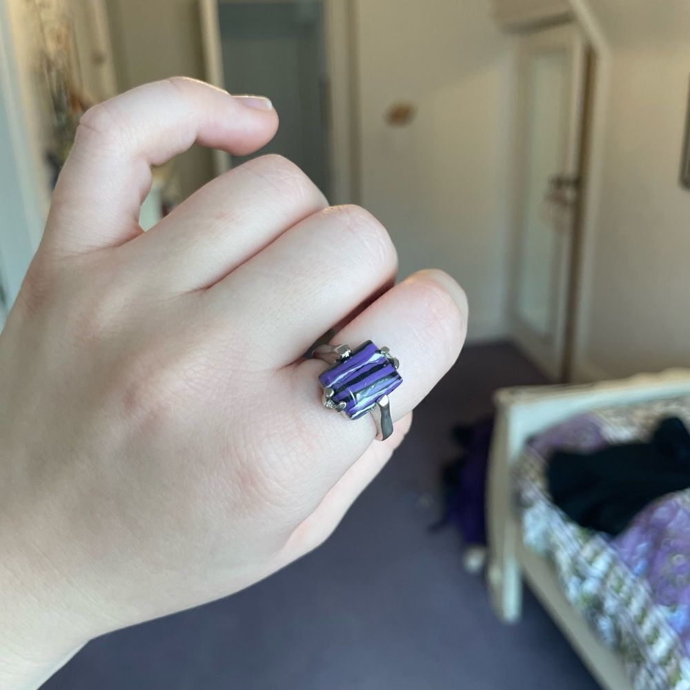 Silver colored ring with a purple stone